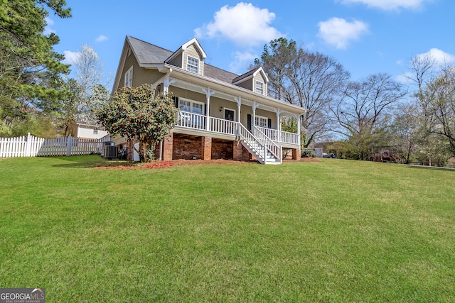 view of front of house with covered porch, central AC, a front lawn, and fence