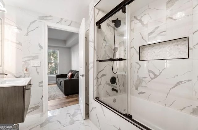 full bathroom featuring vanity, ensuite bath, marble finish floor, and enclosed tub / shower combo