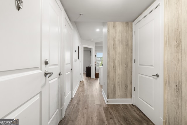 corridor featuring baseboards and wood finished floors