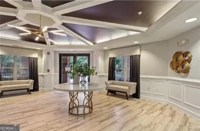 living area with recessed lighting, a wainscoted wall, a raised ceiling, and a decorative wall