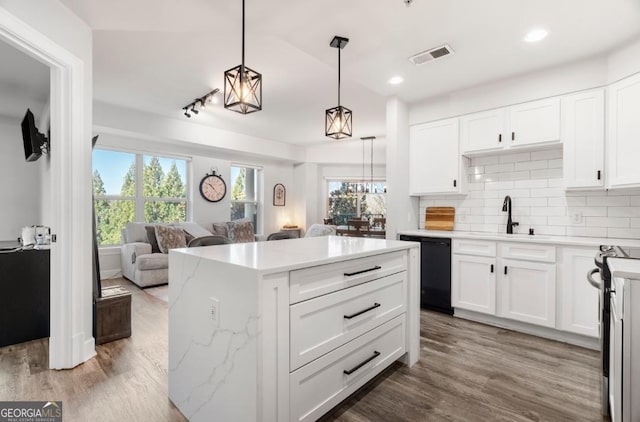 kitchen featuring visible vents, a sink, dishwasher, open floor plan, and backsplash