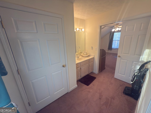 bathroom featuring vanity, ceiling fan, and a textured ceiling