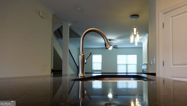 room details featuring crown molding, a ceiling fan, and a sink