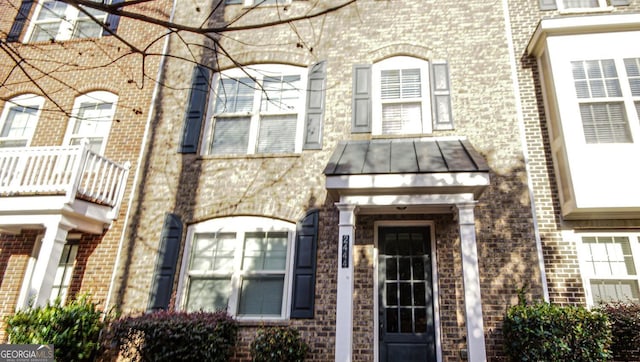 property entrance with brick siding, metal roof, and a standing seam roof