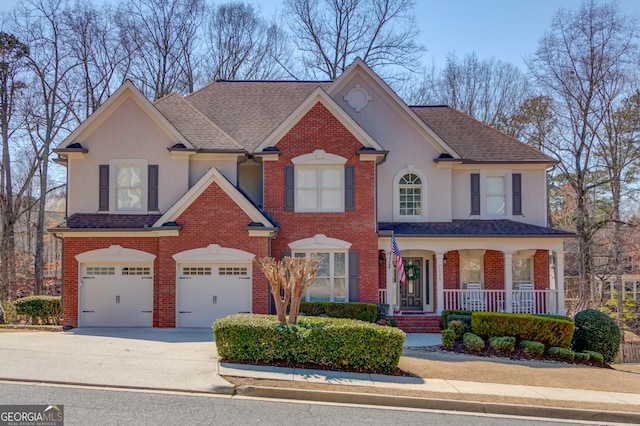 view of front of home featuring brick siding, stucco siding, concrete driveway, and a garage