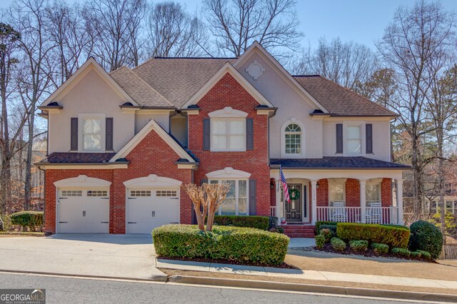 1175 Lamont Cir, Dacula, GA 30019 - view of front of house with a garage, stucco siding, a porch, and concrete driveway