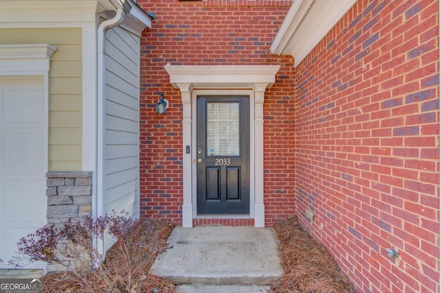 entrance to property featuring brick siding