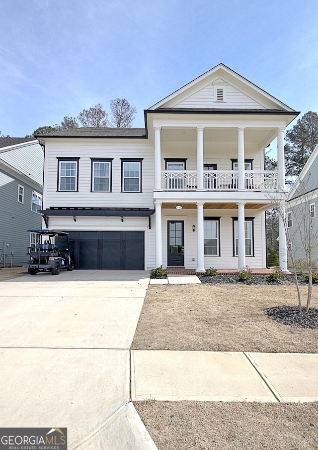 neoclassical / greek revival house with a balcony, covered porch, a garage, and driveway