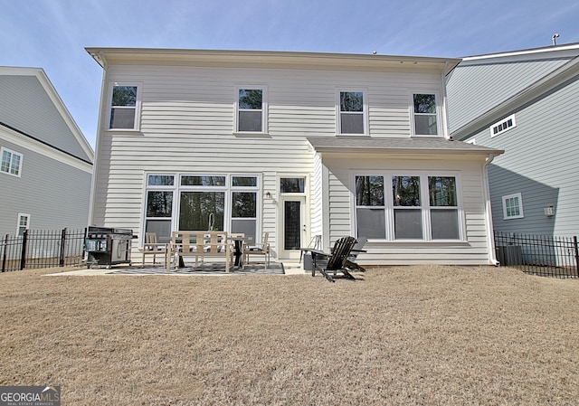 rear view of house with a patio and fence