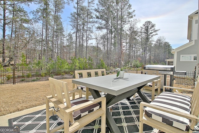 deck with area for grilling, outdoor dining area, and fence