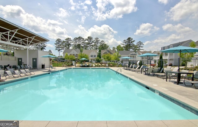 pool with a patio area, a residential view, electric panel, and fence