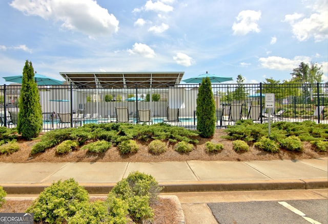 view of community with a swimming pool and fence