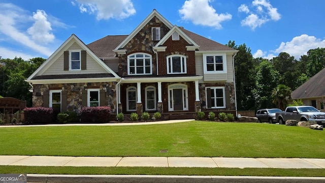 craftsman-style house featuring a front lawn and stone siding