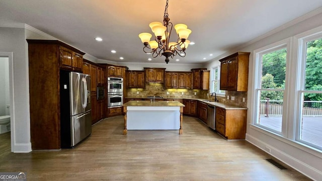838 Natchez Valley Trce NE, Grayson, GA 30017 - kitchen featuring appliances with stainless steel finishes, a chandelier, light wood finished floors, backsplash, and ornamental molding