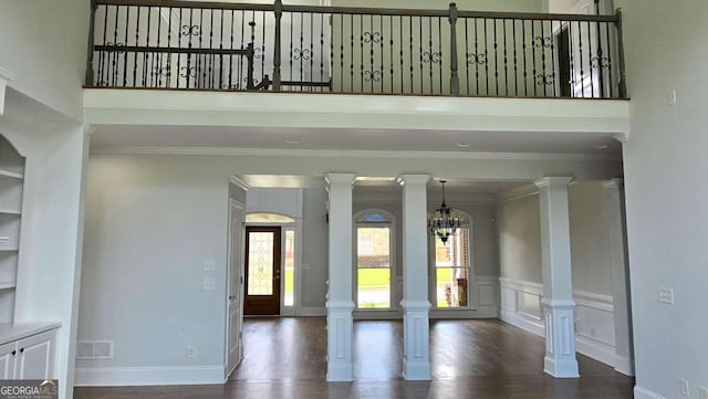 838 Natchez Valley Trce NE, Grayson, GA 30017 - unfurnished living room featuring wood finished floors, ornamental molding, a chandelier, and a towering ceiling