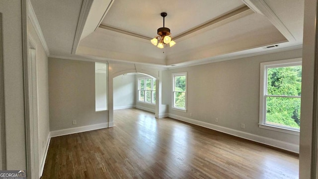 838 Natchez Valley Trce NE, Grayson, GA 30017 - unfurnished room featuring a tray ceiling, arched walkways, ornamental molding, wood finished floors, and a ceiling fan