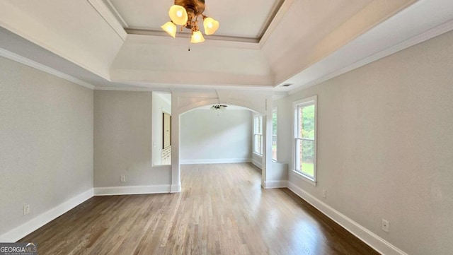 838 Natchez Valley Trce NE, Grayson, GA 30017 - spare room featuring a raised ceiling, a ceiling fan, ornamental molding, wood finished floors, and arched walkways