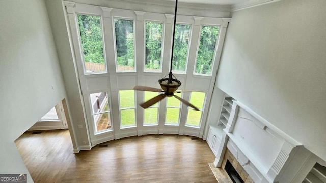 838 Natchez Valley Trce NE, Grayson, GA 30017 - unfurnished living room featuring healthy amount of natural light, a towering ceiling, ceiling fan, wood finished floors, and a fireplace