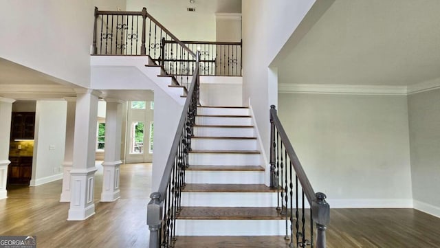 838 Natchez Valley Trce NE, Grayson, GA 30017 - stairs with decorative columns, crown molding, wood finished floors, and a high ceiling