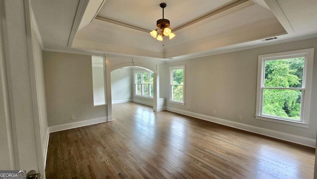 838 Natchez Valley Trce NE, Grayson, GA 30017 - empty room featuring a raised ceiling, arched walkways, a ceiling fan, dark wood-type flooring, and ornamental molding