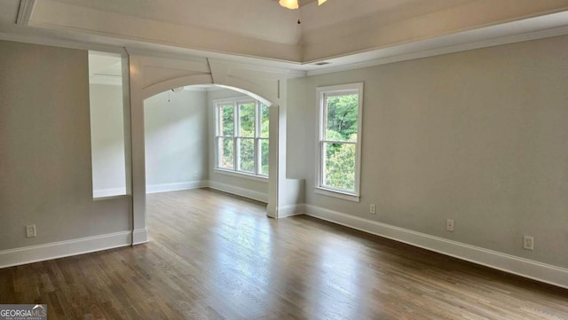 838 Natchez Valley Trce NE, Grayson, GA 30017 - unfurnished room with dark wood-style floors, crown molding, arched walkways, and a tray ceiling