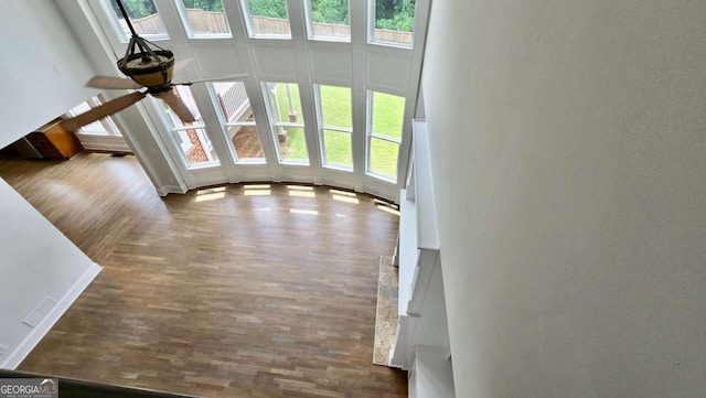 838 Natchez Valley Trce NE, Grayson, GA 30017 - unfurnished living room featuring plenty of natural light, a ceiling fan, wood finished floors, and a towering ceiling