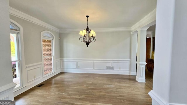 838 Natchez Valley Trce NE, Grayson, GA 30017 - unfurnished dining area with a chandelier, wood finished floors, wainscoting, ornamental molding, and ornate columns