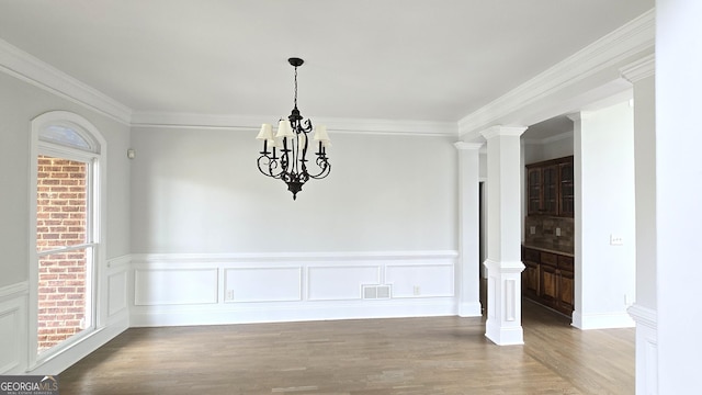 838 Natchez Valley Trce NE, Grayson, GA 30017 - unfurnished dining area with wood finished floors, a chandelier, crown molding, a wainscoted wall, and healthy amount of natural light