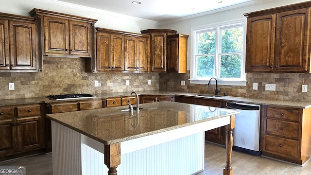 838 Natchez Valley Trce NE, Grayson, GA 30017 - kitchen with stainless steel dishwasher, gas stovetop, dark stone countertops, light wood-style flooring, and crown molding