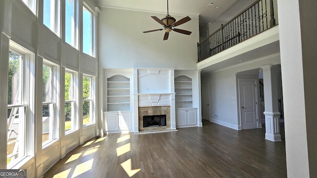 838 Natchez Valley Trce NE, Grayson, GA 30017 - unfurnished living room with a high ceiling, wood finished floors, a ceiling fan, and a tile fireplace