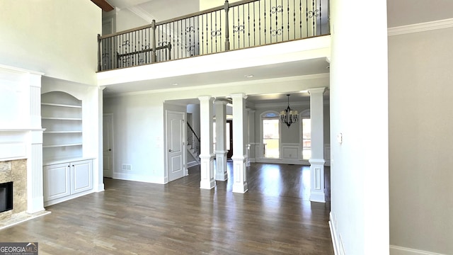 838 Natchez Valley Trce NE, Grayson, GA 30017 - unfurnished living room with wood finished floors, built in shelves, stairway, a premium fireplace, and crown molding