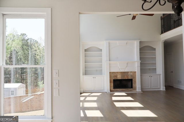 838 Natchez Valley Trce NE, Grayson, GA 30017 - unfurnished living room with a fireplace, ceiling fan, wood finished floors, and built in shelves