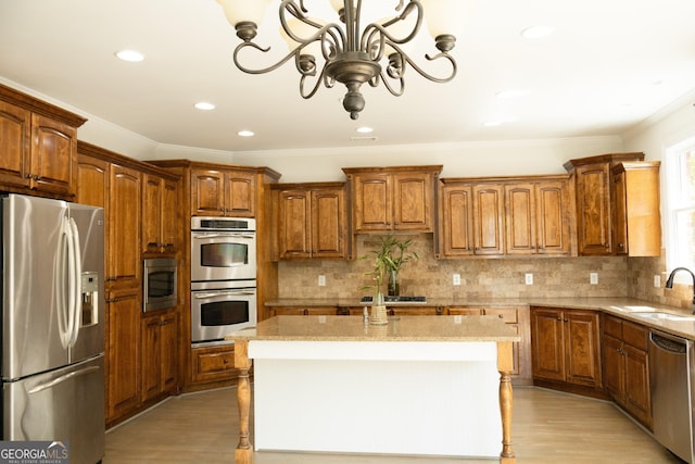 838 Natchez Valley Trce NE, Grayson, GA 30017 - kitchen featuring appliances with stainless steel finishes, a chandelier, light stone countertops, light wood-style floors, and crown molding