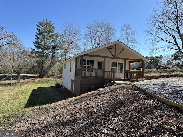 view of front facade with a porch, a front yard, and board and batten siding