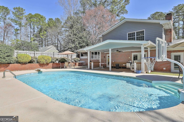 view of swimming pool with a patio area, a fenced in pool, and fence