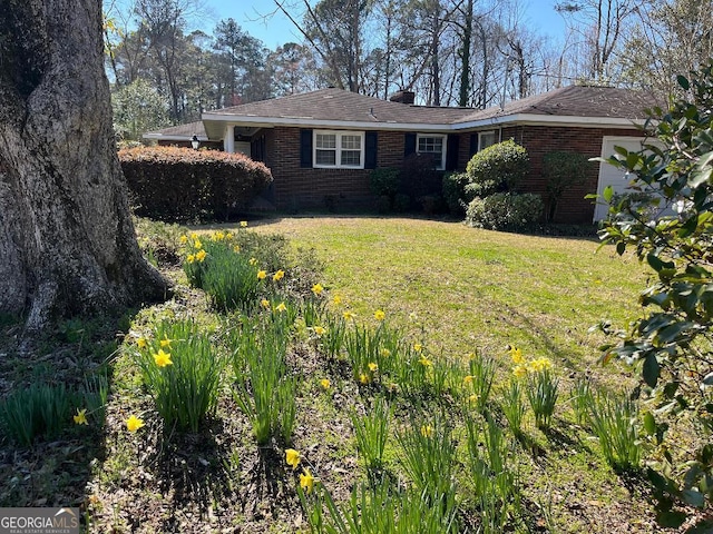 exterior space featuring a lawn, brick siding, and a chimney