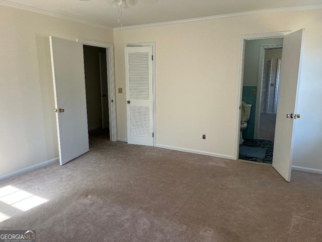 unfurnished bedroom with ensuite bathroom, baseboards, carpet floors, and ornamental molding