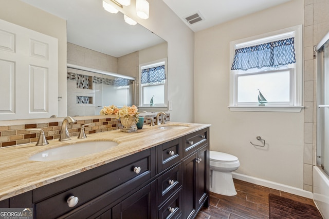 bathroom with a sink, visible vents, backsplash, and wood finished floors