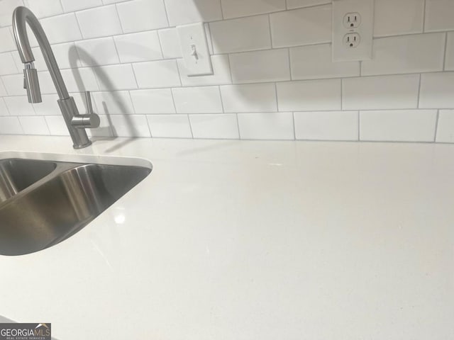 interior details featuring light countertops, tasteful backsplash, and a sink