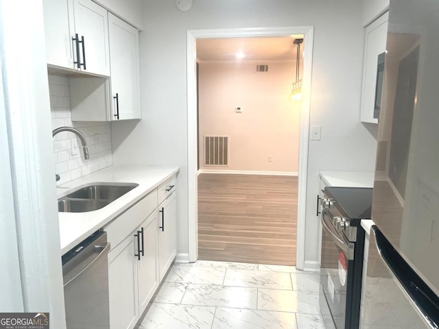 kitchen with marble finish floor, dishwasher, visible vents, a sink, and wall oven