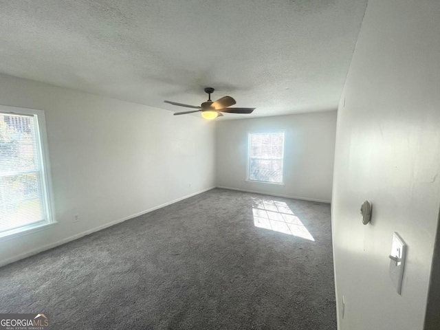 carpeted empty room with ceiling fan, baseboards, and a textured ceiling