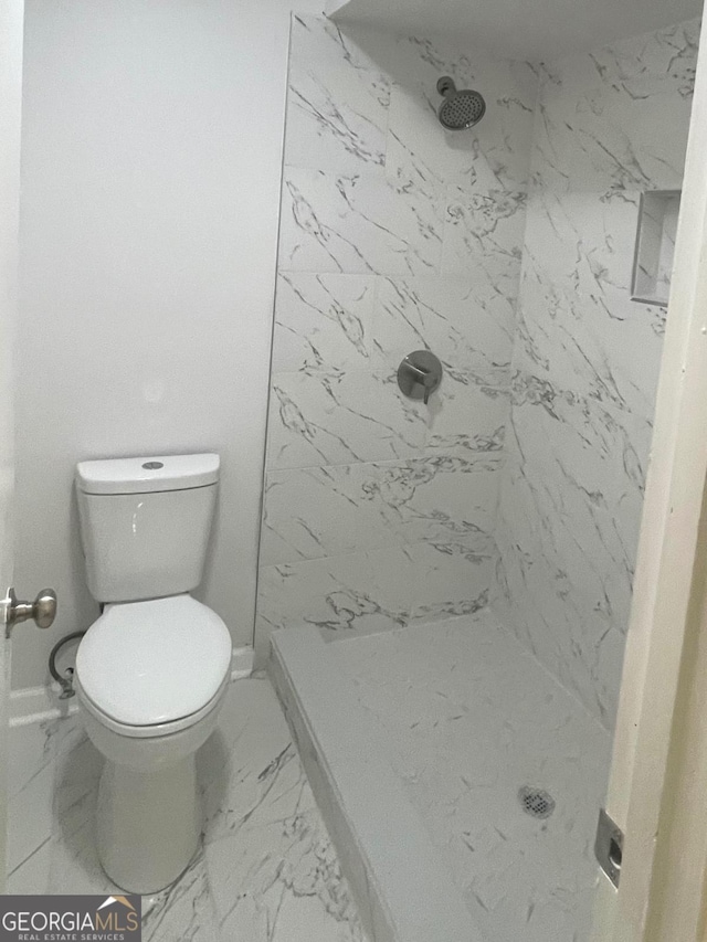 full bathroom featuring marble finish floor, toilet, a marble finish shower, and baseboards