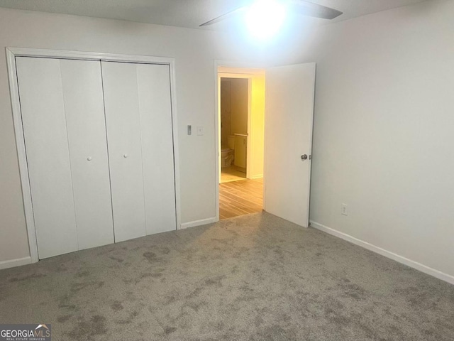 unfurnished bedroom with baseboards, carpet floors, and a closet