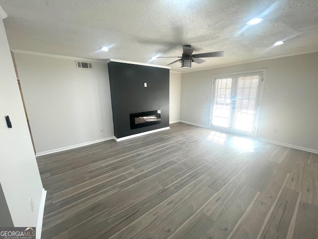 unfurnished living room with a textured ceiling, visible vents, ceiling fan, crown molding, and a fireplace