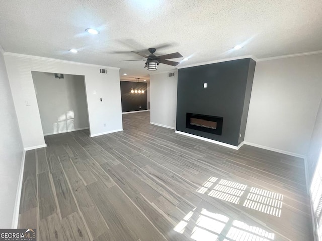 unfurnished living room with ceiling fan, baseboards, ornamental molding, and a textured ceiling