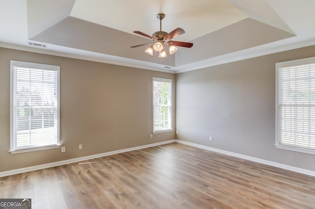 unfurnished room featuring a tray ceiling, baseboards, visible vents, and ceiling fan