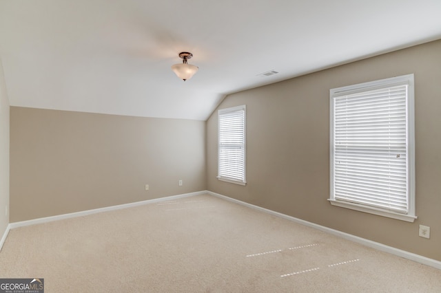 additional living space with visible vents, baseboards, carpet, and vaulted ceiling