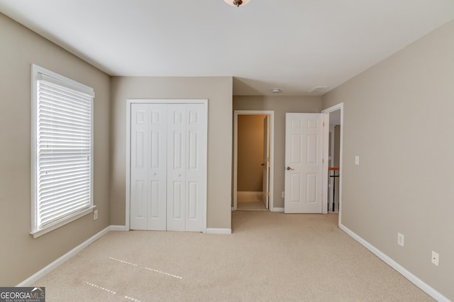 unfurnished bedroom with multiple windows, carpet flooring, and baseboards