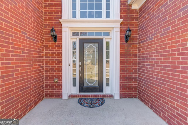 property entrance featuring brick siding