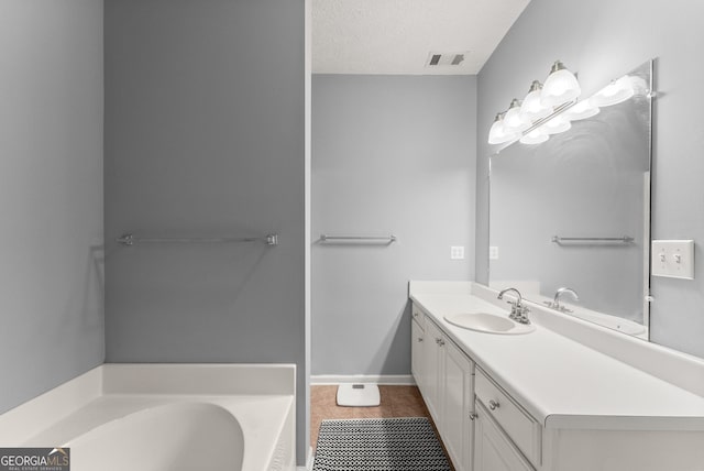 full bath with vanity, visible vents, tile patterned flooring, a textured ceiling, and a garden tub